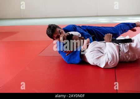 Judokas pratiquant le judo pendant un entraînement dans une salle de sport Banque D'Images