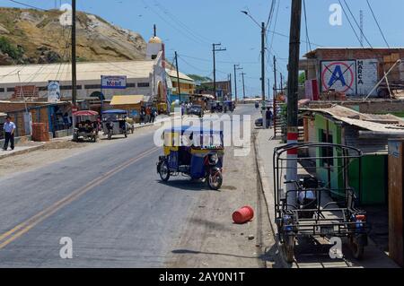 En regardant dans une rue à la Cruz avec des gens faisant du shopping et Motorbike taxis sur la route. Banque D'Images