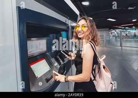 Femme asiatique achetant un billet de transport à la station de métro Banque D'Images