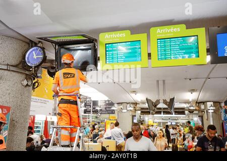 24 juillet 2019, Lyon, France: Les travailleurs de la SNCF dépannent l'affichage des horaires des trains sur les moniteurs dans la salle d'attente de la gare Banque D'Images