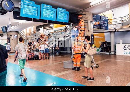 24 juillet 2019, Lyon, France: Les travailleurs de la SNCF dépannent l'affichage des horaires des trains sur les moniteurs dans la salle d'attente de la gare Banque D'Images