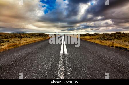 Route droite à travers un paysage rural, Islande Banque D'Images