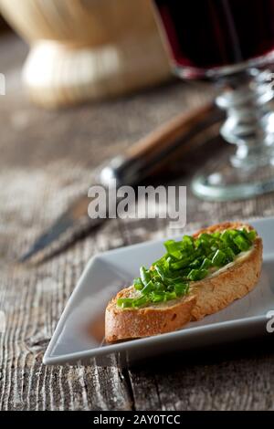 Baguette avec beurre et ciboulette sur la plaque Banque D'Images