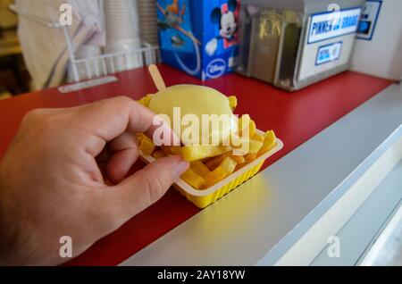 Oosterscheldekering, Pays-Bas, Août 2019. Le plat principal d'un kiosque à cuisine de rue : frites. Une partie est prête à être dégustée, une main est t Banque D'Images