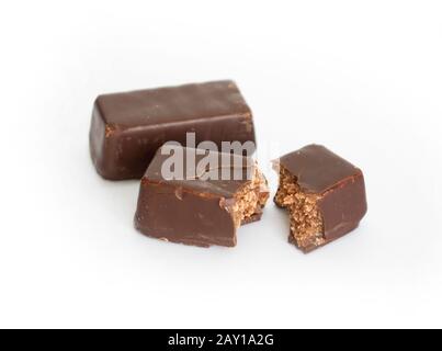 bonbons au chocolat isolés sur fond blanc. Bar cassé avec farce au milieu. Banque D'Images