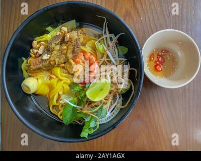 Cuisine vietnamienne - nouilles de riz Mi Quang servies avec sauce au poisson Banque D'Images