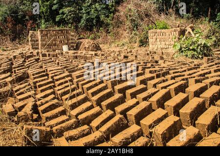 Fabrication de briques d'argile maison en Ouganda. Les briques sont séchées au soleil dehors Banque D'Images