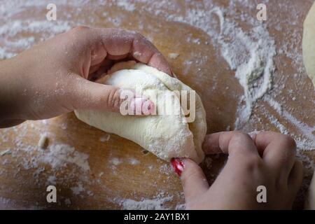 Femme chef mains préparant des tartes pour le dessert pour le thé. Pâte crue avec tranches de pomme pour la cuisson au four. Banque D'Images