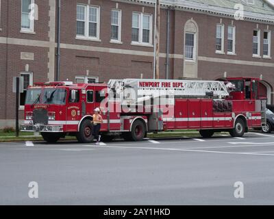 Newport, Rhode Island-septembre 2017 : les pompiers de Newport Fire Department se trouvent à un trottoir, avec une femme qui fait du jogging à côté. Banque D'Images