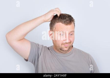 Jeune homme avec expression confuse sur le visage Banque D'Images