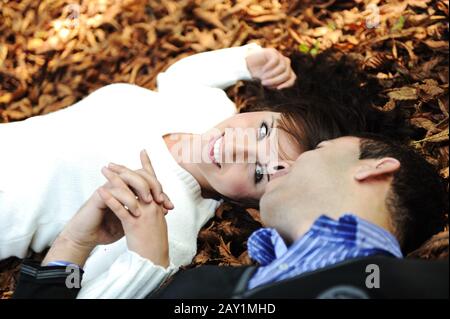 Portrait d'un couple amoureux en plein air dans un parc qui a l'air heureux sur le terrain d'automne Banque D'Images