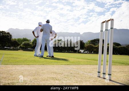 Les joueurs de cricket discutent sur le terrain Banque D'Images