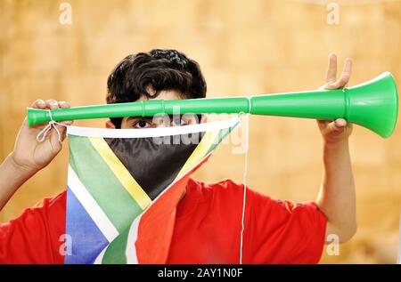 encouragement avec vuvuzela et drapeau Banque D'Images