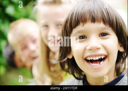 Photo de heureux les filles avec de beaux mecs en face smiling at camera Banque D'Images