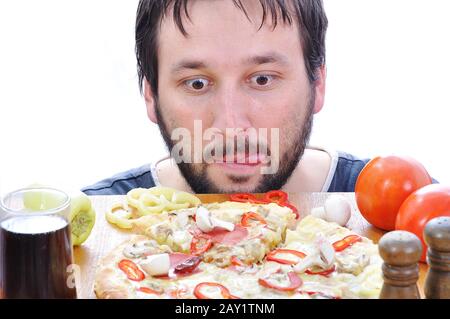 Personne adulte avec visage surpris sur la table à pizza Banque D'Images