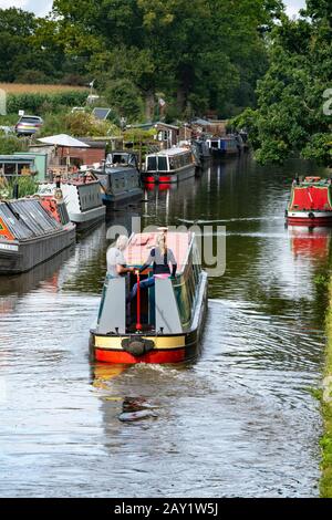 Une femme aux cheveux blonds vole le bateau à narrowboat long le Shroppie dans le Staffordshire. Banque D'Images