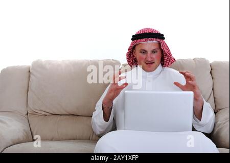 Homme arabe utilisant un ordinateur portable à la maison Banque D'Images