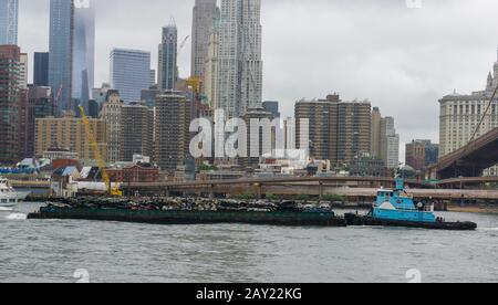 New York, États-Unis - 20 août 2018 : remorqueur poussant une barge chargée de déchets sur la rivière East à New York Banque D'Images