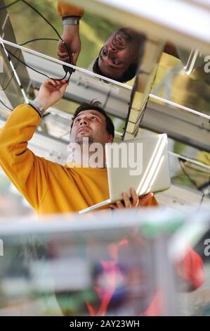 Jeune expert travaillant sur des panneaux solaires Banque D'Images