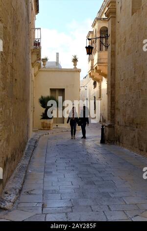 Deux femmes marchant dans une ruelle étroite dans l'ancienne ville de Mdina, Malte. La ville était le lieu de tournage du jeu de Thrones fictional capita Banque D'Images