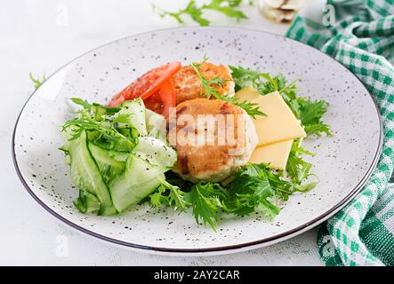 Déjeuner cétogène. Hamburger de poulet avec salade de tomates, concombres, fromages et arugula sans pain. Patties de poulet. Des aliments sains. Régime de céto/paleo. Banque D'Images