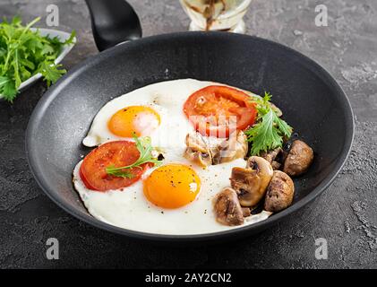 Nourriture cétogène. Œufs frits, champignons et tomates en tranches. Keto, petit déjeuner paleo. Banque D'Images