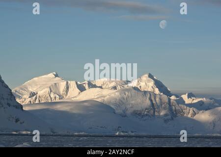 Montagnes de l'Antarctique sous la lumière du lune une journée. Banque D'Images