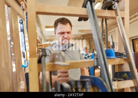 Young Carpenter travaille avec des pinces dans la menuiserie Banque D'Images