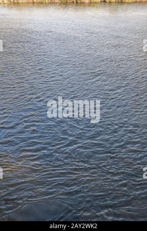 Des vagues d'eau calmes sur la rivière Fowey à Lostwithiel à Corrnwall, avec une rive éloignée de la rivière. Métaphore temps équitable, effet d'ondulation, réflexions de l'eau. Banque D'Images