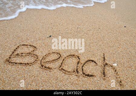 Mot de plage écrit sur la plage de sable Banque D'Images