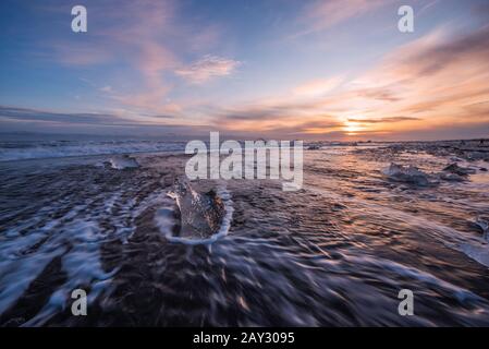 La glace brisée d'icebergs échoués sur la plage noire Jökulsárlón Jökulsárlón au coucher du soleil au sud est de l'Islande Banque D'Images