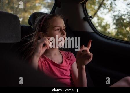 Une fille de 8 à 10 ans balade en voiture. Exploration de la nature, les voyages, les vacances en famille. Une fille de 9 ans rides comme passager dans une voiture ou dans un taxi g Banque D'Images