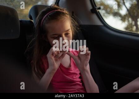 Une fille de 8 à 10 ans balade en voiture. Exploration de la nature, les voyages, les vacances en famille. Une fille de 9 ans rides comme passager dans une voiture ou dans un taxi g Banque D'Images