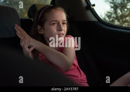 Une fille de 8 à 10 ans balade en voiture. Exploration de la nature, les voyages, les vacances en famille. Une fille de 9 ans rides comme passager dans une voiture ou dans un taxi g Banque D'Images