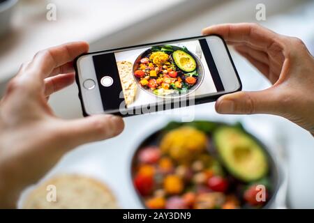 Gros Plan De La Femme Prenant Photo De Repas De Vegan Sur Téléphone Mobile Banque D'Images