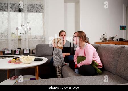 Mère avec filles sur canapé Banque D'Images