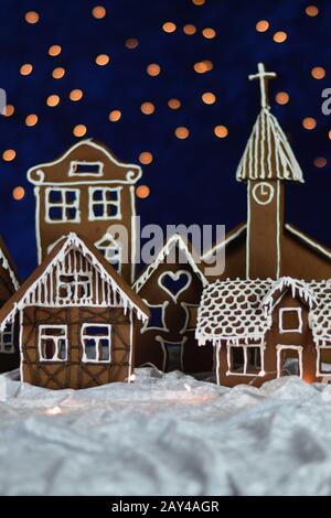 maison a fait la ville de pain d'épices avec église et ciel bokeh hors de velours bleu et lumières de noël comme décoration d'arrivée pour la famille Banque D'Images