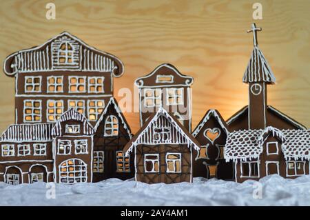 maison a fait traditionnel doux délicieux village de pain d'épices cuit au four en face de fond en bois sur le velours blanc de neige comme la décoration de noël pour le Banque D'Images