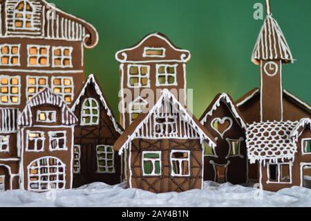 maison a fait traditionnel sucré délicieux village de pain d'épice cuit au four en face de fond vert sur le velours blanc de neige comme la décoration de noël pour le Banque D'Images