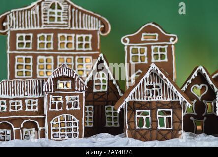 maison a fait traditionnel sucré délicieux village de pain d'épice cuit au four en face de fond vert sur le velours blanc de neige comme la décoration de noël pour le Banque D'Images