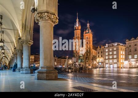 Place du marché de Cracovie avec basilique St Mary la nuit, Cracovie, Pologne Banque D'Images