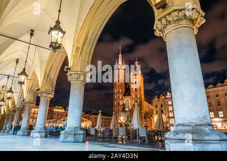 Place du marché de Cracovie avec basilique St Mary la nuit, Cracovie, Pologne Banque D'Images