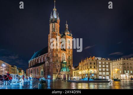 Place du marché de Cracovie avec basilique St Mary la nuit, Cracovie, Pologne Banque D'Images