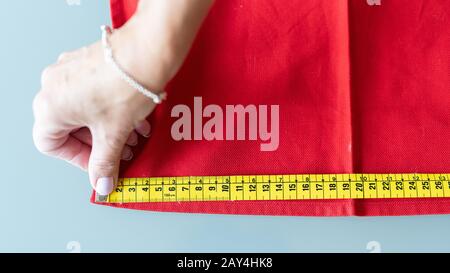 La mesure d'une femme à la main avec du tissu au mètre. Banque D'Images