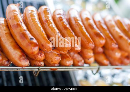 Un bouquet de saucisses ou de bratwurts délicieux sur un grand barbecue à l'occasion d'un événement festif, griller sur le gril ouvert, Banque D'Images