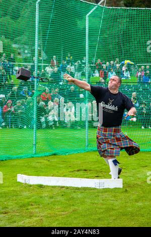 Port de Tartan a Kilted Competitor, mettant la pierre, aux Jeux écossais des Highlands de Braemar, Écosse, Royaume-Uni  des jets lourds Banque D'Images