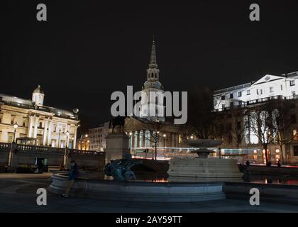 Tir de nuit de la fontaine d'eau de Trafalgar Square avec St Martin dans les champs derrière à Londres, Royaume-Uni Banque D'Images