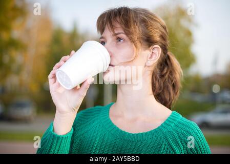 Heureux jeune étudiante fille de boire du café à emporter. Banque D'Images