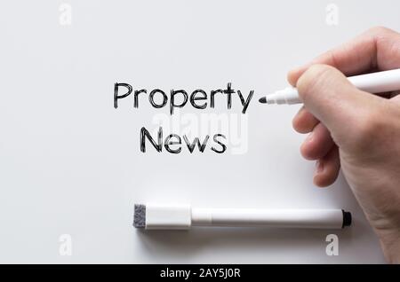 Property news written on whiteboard Banque D'Images