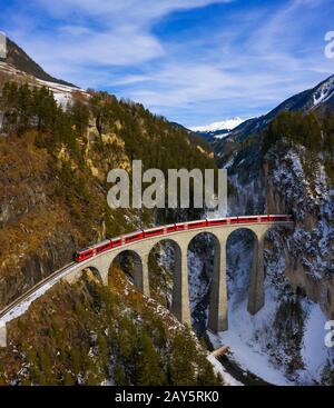 Train rouge sur le Landwasser Viadukt en hiver. Filisur, Canton De Graubunden, Suisse, Europe Du Sud Banque D'Images